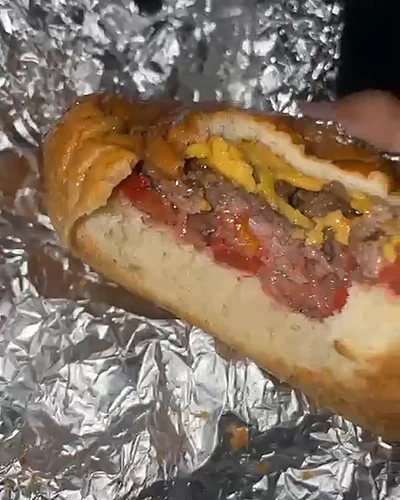 La Burger Amante Clásica partida en dos, sobre su papel aluminio